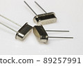 Crystal resonator in metal body on white background. Electronic components. 89257991