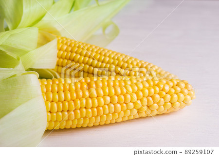 Fresh corn on the cob on a wooden white table, close-up 89259107