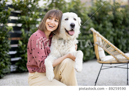 Portrait of a woman with her dog at backyard Portrait of a woman with her dog at backyard 89259590