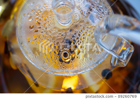 Transparent kettle with brewed tea inside. A fogged kettle lid. Droplets of water accumulated on the lid of the kettle Transparent kettle with brewed tea inside. A fogged kettle lid. Droplets of water accumulated on the lid of the kettle 89260769