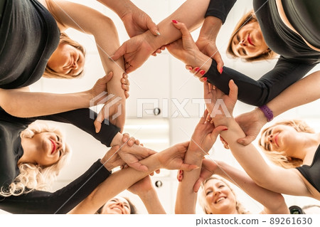 Team of people holding hands. Group of happy young women holding hands. Bottom view, low angle shot of human hands. Friendship and unity concept 89261630