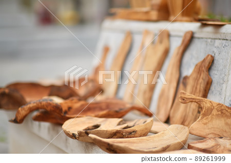 Kitchen utensils on outdoors Easter festival or weekend agricultural fair. Plates, bowls and cutting boards make of olive wood Kitchen utensils on outdoors Easter festival or weekend agricultural fair. Plates, bowls and cutting boards make of olive wood 89261999