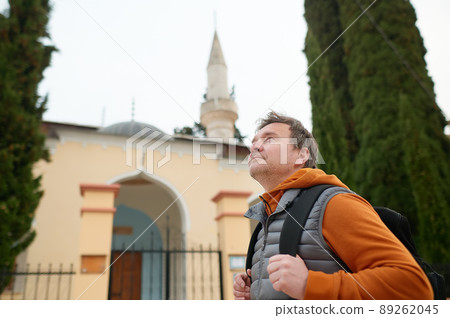 Tourist enjoy a stroll through the old town of Trebinje, Bosnia and Herzegovina. Backpacker examines the facade of Osman Pasha Mosque in the historical center of the Trebinye Tourist enjoy a stroll through the old town of Trebinje, Bosnia and Herzegovina. Backpacker examines the facade of Osman Pasha Mosque in the historical center of the Trebinye 89262045