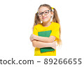Cheerful young child girl with glasses holding a book to study isolated on a white background. 89266655