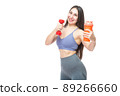 A beautiful, athletic, slim, smiling and cheerful woman holds a red dumbbell and a shaker with water. Lifestyle concept with sports and gym. Isolated on white background. 89266660