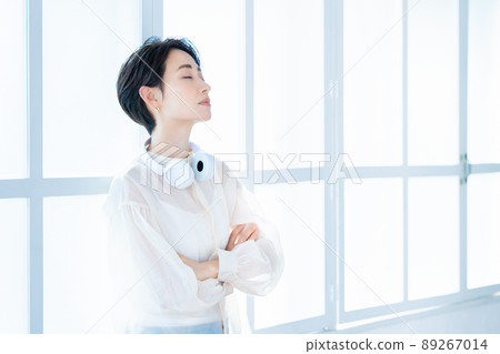 Middle-aged woman wearing headphones around her neck 89267014