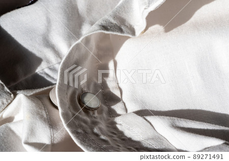 button extender shown on a white dress shirt to increase size 89271491