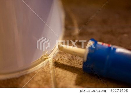 Selective focus on silicone caulking ready to be applied around the seal of a bathroom toilet. 89271498