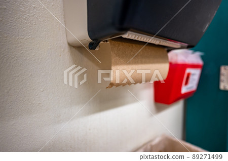 selective focus on a paper towel dispenser in a restroom used for drying hands after washing. selective focus on a paper towel dispenser in a restroom used for drying hands after washing. 89271499