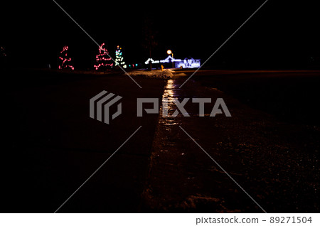 Ice and snow on a sidewalk at night with streetlight reflecting off the slick surface. Ice and snow on a sidewalk at night with streetlight reflecting off the slick surface. 89271504