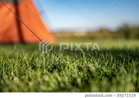 Selective focus on tent support rope leading up to the canvas to secure in-place Selective focus on tent support rope leading up to the canvas to secure in-place 89271519