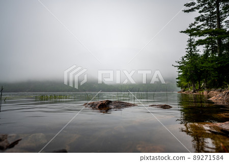 Waters edge of Jordan Pond in Acadia National Park, Maine, USA with fog setting into the distance  89271584