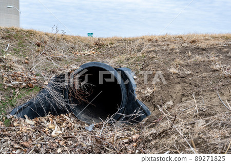 HDPE drainage culvert under a road entrance. Pipe is used to convey stormwater between ditches. 89271825