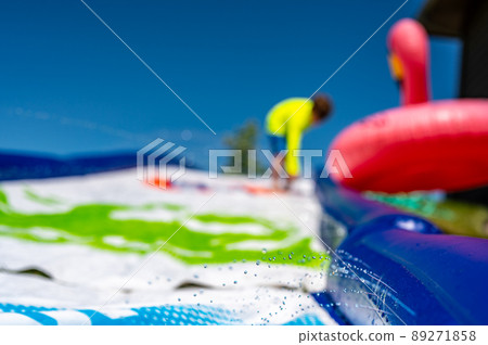 Selective focus on jets of droplets shooting out across a water slide 89271858