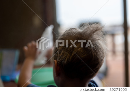 Young male boy helping in the kitchen with messy hair sticking up 89271903