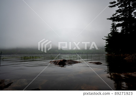 Waters edge of Jordan Pond in Acadia National Park, Maine, USA with fog setting into the distance  89271923