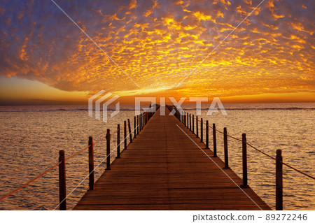 orange sky with spindrift clouds on sunrise in Egypt and wooden bridge in sea orange sky with spindrift clouds on sunrise in Egypt and wooden bridge in sea 89272246