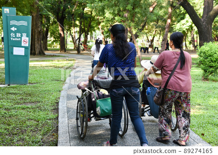 Elderly life walks caregiver and elderly in the park 89274165