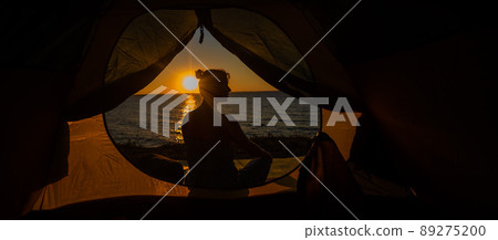 A woman and a dog in a tourist tent at sunrise. Camping with a pet A woman and a dog in a tourist tent at sunrise. Camping with a pet 89275200