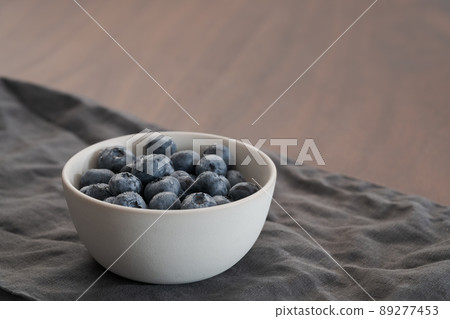 Fresh washed blueberries in white bowl on linen napkin Fresh washed blueberries in white bowl on linen napkin 89277453