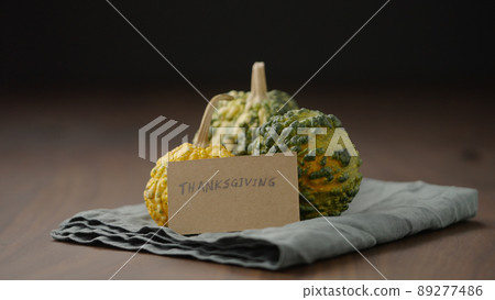 man put thanksgiving greeting with decorative pumpkins on wood table 89277486