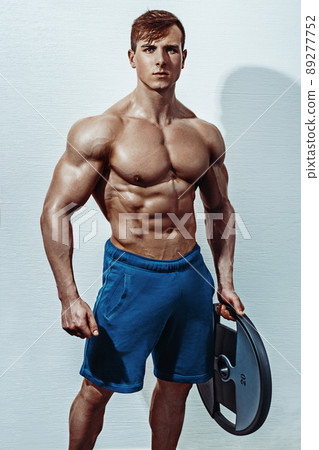 Male bodybuilder, fitness model trains in the gym Male bodybuilder, fitness model trains in the gym 89277752
