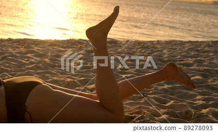 Woman relaxes at the beach of Miami at sunset - beautiful silhouette shot Woman relaxes at the beach of Miami at sunset - beautiful silhouette shot 89278093