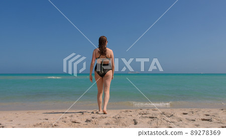 Beautiful woman in a bathing suit enjoys the blue ocean water at Miami Beach 89278369