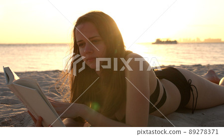 Woman relaxes at the beach of Miami at sunset - beautiful silhouette shot 89278371