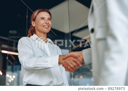 Close up of two confident businesswoman are handshaking before meeting in modern office 89278973
