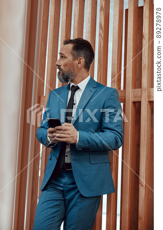 Caucasian man with smartphone looking away in office space 89278978