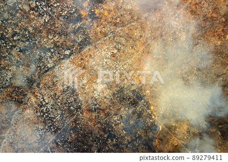 Drone aerial view of wildfire in the mountains. Overhead view on burning trees and grass among the rocky mountains. Seasonal fires in Montenegro. 89279411