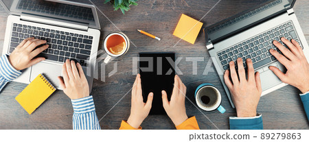 Three unrecognizable people laptop for remote working or studying top view Three unrecognizable people laptop for remote working or studying top view 89279863