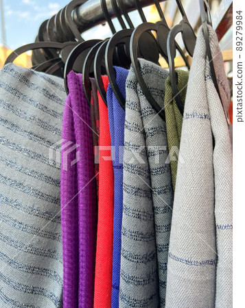 colorful trendy and fashionable scarves hanging on rack in a cloth store colorful trendy and fashionable scarves hanging on rack in a cloth store 89279984