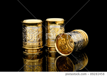Antique Vintage Brass Shot Glass Gilded on Black background Antique Vintage Brass Shot Glass Gilded on Black background 89281458