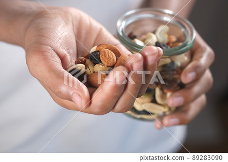 young men eating mixed nut young men eating mixed nut 89283090