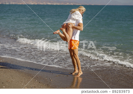 Man holding woman, squeezing her buttocks. Couple having fun together on a beach during vacation 89283973