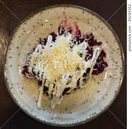 mix of beets, cheese, mayonnaise on a plate in restaurant. top view 89284362