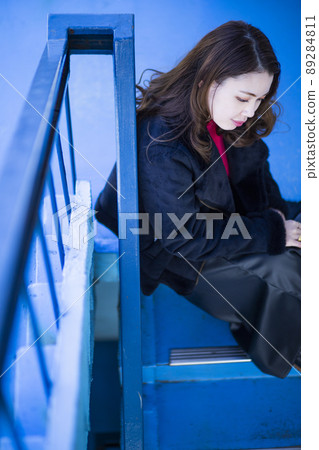 Portrait of a woman sitting on the stairs 89284811