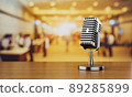 Close up of old vintage style podcast microphone in convention hall and blurry people background. Entertainment and conference concept 89285899