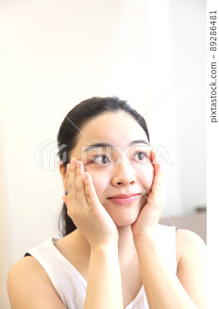 Happy young woman touching her cheeks Happy young woman touching her cheeks 89286481