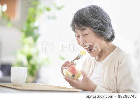 Senior woman eating fruit Senior woman eating fruit 89286743