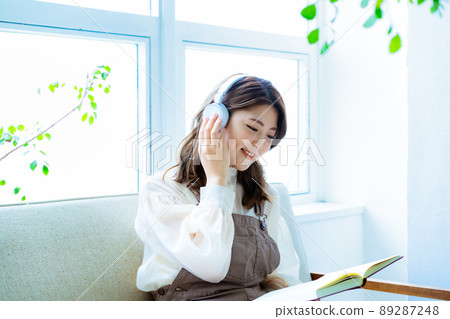 A young woman reading while listening to music 89287248
