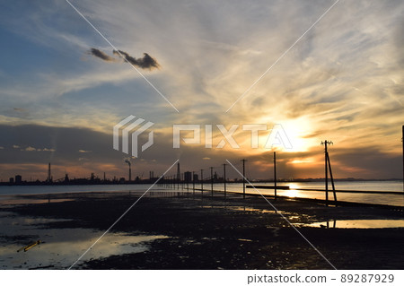 Underwater utility poles at dusk and factories on the opposite bank 89287929