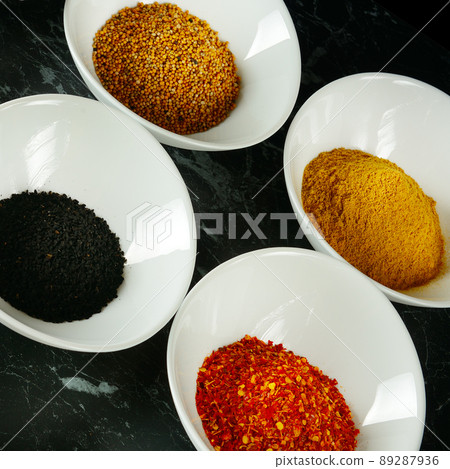 A set of spices in white cups on a black . A set of spices in white cups on a black . 89287936