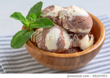 Chocolate-vanilla ice cream in a wooden bowl. 89287953