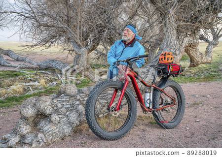 senior cyclist with fat mountain bike in Colorado prairie 89288019