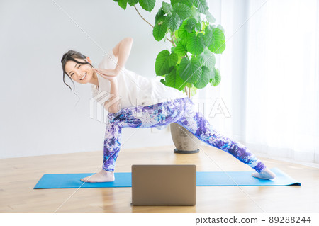 Young woman doing online yoga at home 89288244