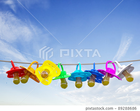 Row of child pacifier, soother and baby dummies on rope. Row of child pacifier, soother and baby dummies on rope. 89288686