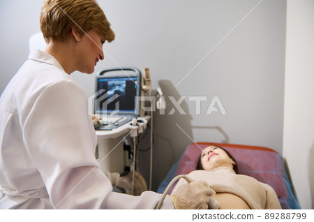 Confident female gynecologist examines a pregnant woman at an early stage of pregnancy on a modern ultrasound machine 89288799